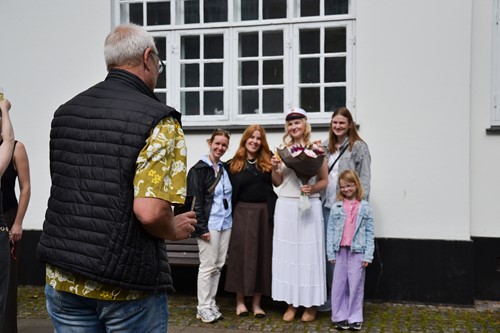 Stolte venner og familie fotograferer de nydudklækkede studenter
